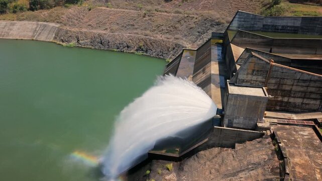 Cinematic drone Aerial shot above a massive water dam in Vietnam with powerful water discharge flowing downward, creating an epic infrastructure and nature scene in 4K.