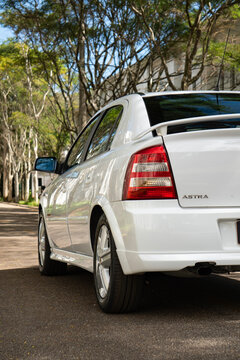 White Chevrolet Astra GSI rear three quarters closeup outdoors, Classic hot hatch in tree lined street