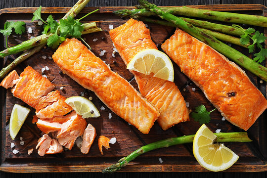 fried salmon with asparagus and lemon on a board