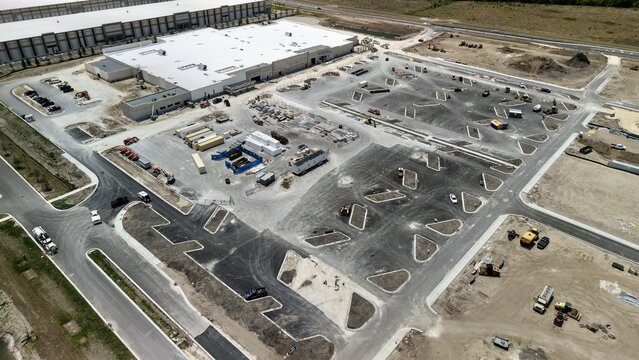 Aerial view of the construction site at Foundry Lane featuring a large warehouse building and a newly paved parking lot in World Golf Village, Florida, United States.