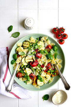 Traditional italian pasta primavera with spring vegetables. Top view with copy space.
