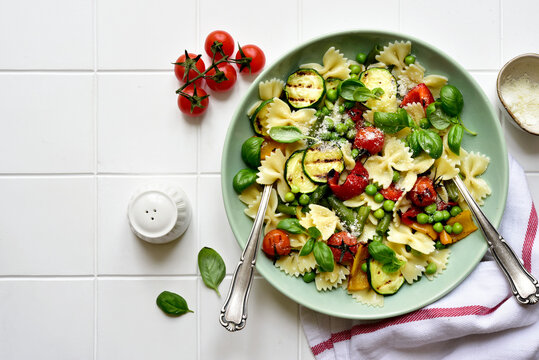 Traditional italian pasta primavera with spring vegetables. Top view with copy space.
