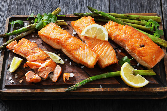 fried salmon with asparagus and lemon on a board