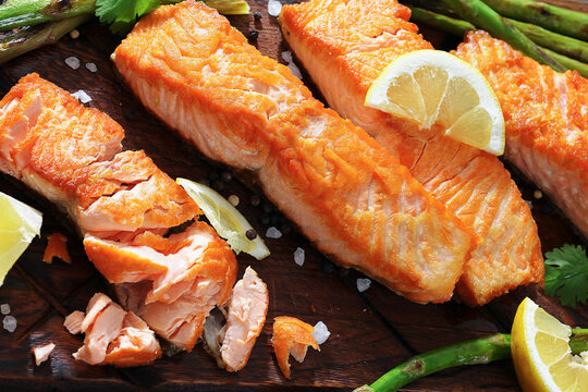 fried salmon with asparagus and lemon on a board