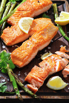 fried salmon with asparagus and lemon on a board