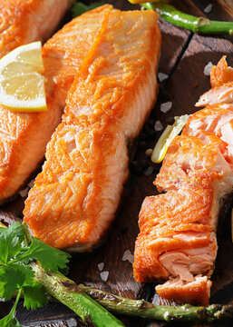 fried salmon with asparagus and lemon on a board