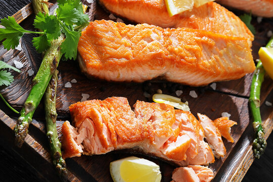 fried salmon with asparagus and lemon on a board