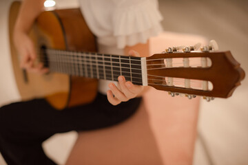 Obraz premium young musician practicing finger style technique on acoustic guitar
