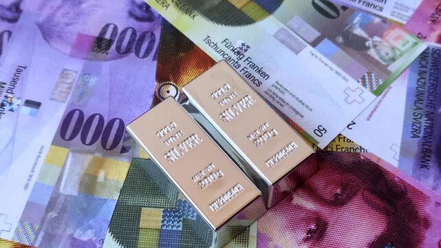 A silver bar, white metal against a backdrop of Swiss flag, as a concept for the sales market. A silver bar as a background for your design