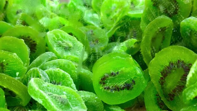 Candied kiwi slices in bulk &mdash; 4K slow motion, pull‑back from close‑up