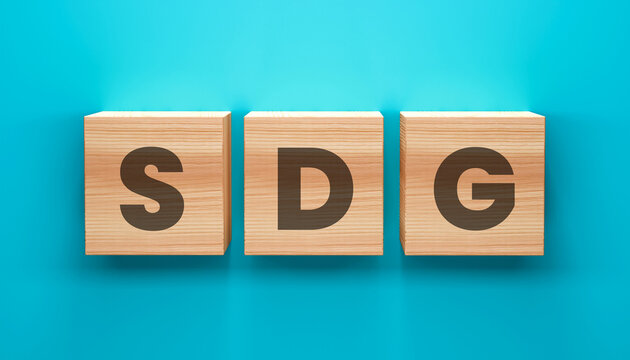 SDG Blocks on Turquoise: Three wooden blocks, emblazoned with the letters SDG, stand against a vibrant turquoise backdrop.