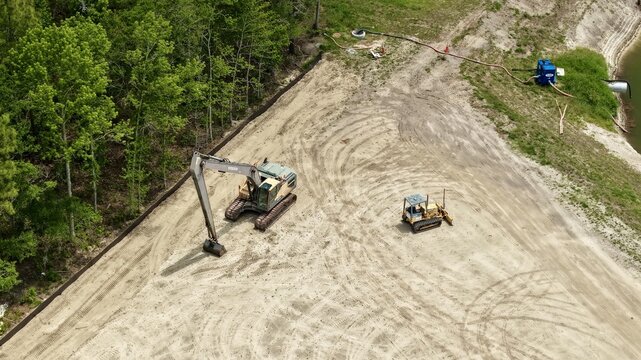 Aerial view of Foundry Lane construction site featuring an excavator and bulldozer on sandy ground near a dense tree line World Golf Village, Florida, United States.
