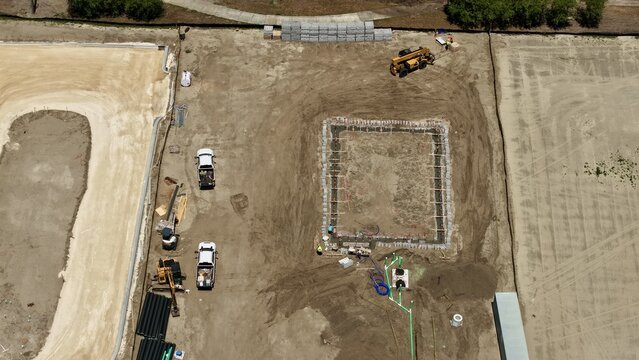 Aerial view of the construction site at Foundry Lane featuring foundation excavation, heavy machinery, and workers on site in World Golf Village, Florida, United States.
