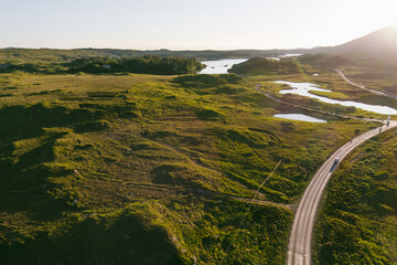 Naklejka premium Roads, lakes and rugged hills spread across the Connemara landscape near Derryclare Lough in County Galway. An aerial view of the wild scenery around Twelve Pines Island in western Ireland.
