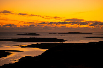 Naklejka premium Sunset glows over Clifden Bay and the Atlantic islands from the Sky Road viewpoint in Connemara, County Galway. A scenic evening view from one of Irelands best coastal lookouts. Wild Atlantic Way.