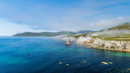 Naklejka premium Misty White Cliffs of Ashleam on Achill Island, County Mayo, Ireland. Dramatic Atlantic sea cliffs and turquoise water on the Wild Atlantic Way.