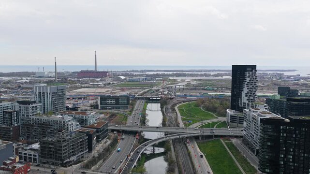 Toronto's bustling city center showing urban infrastructure with Gardiner Expressway, Don River, Port Lands overlooking Lake Ontario under overcast sky