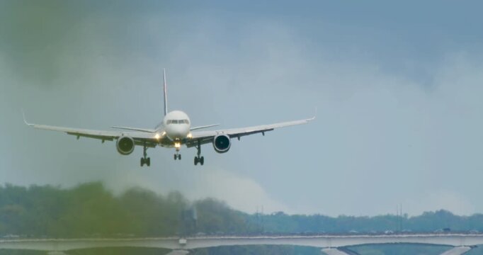 Plane Landing in Slow Motion Obscured by Tree Branch in Foreground