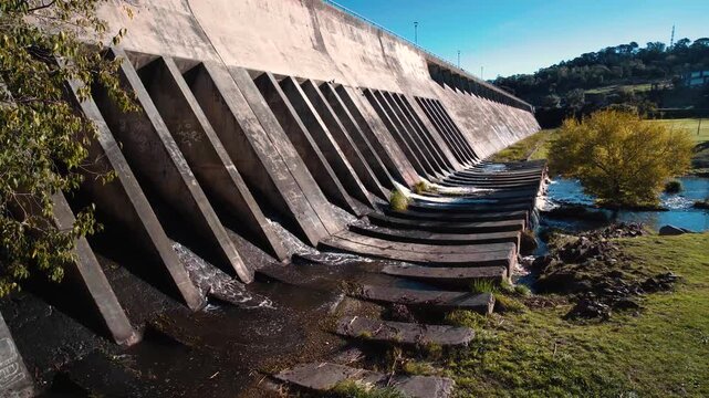 4K video of a dam wall with floodgates releasing water. Hydroelectric infrastructure and water management concept.