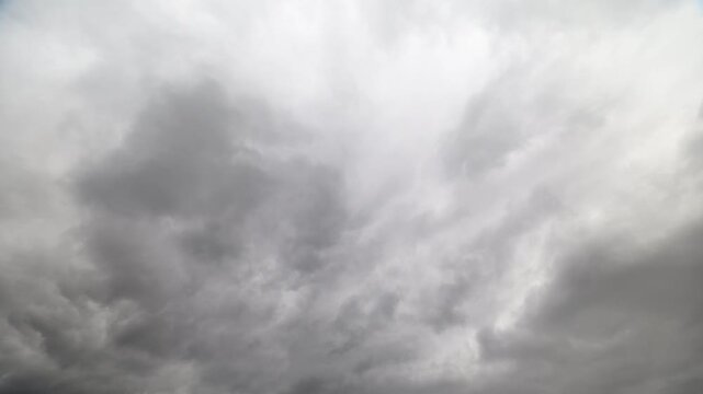 Chaotic sky display. Turbulent gray clouds cascade across vast and moody horizon. Dark stormy weather characterized by swirling clouds moving swiftly and transforming shapes