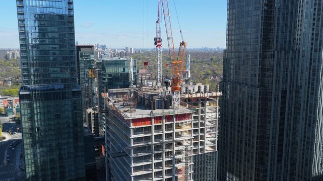 Construction crane building new modern skyscraper in downtown Toronto, showcasing urban expansion and real estate development with impressive city landscape