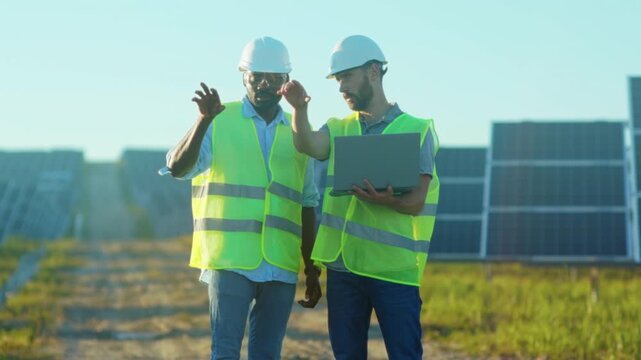 Engineers examine panels collaboratively, Professionals conduct site walk with detailed analysis and discussion
