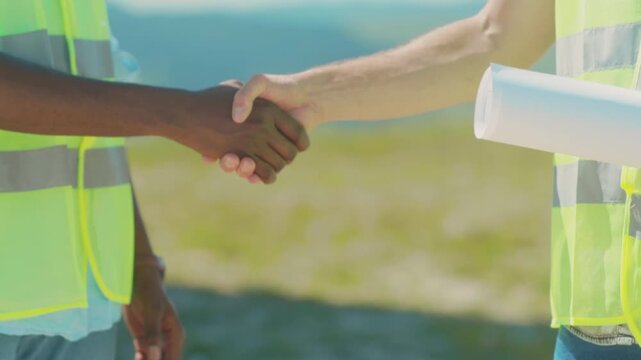 Construction partners confirm project commitment outdoors, Professional team agrees with firm handshake on building site