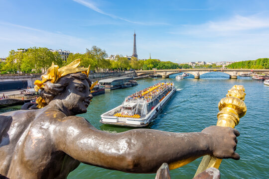 Sculpture on Alexander III bridge over Seine river with Eiffel tower at background, Paris, France