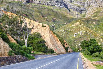 Naklejka premium Landscape, outdoor and road on mountain for travel, tourist destination and journey for adventure. Empty, background and street with scenic route, highway and nature for vacation, trip and holiday