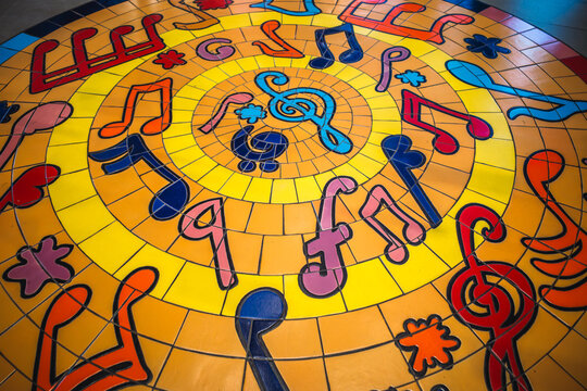 Colorful mosaic floor tiles depicting musical notes and symbols in a circular pattern.