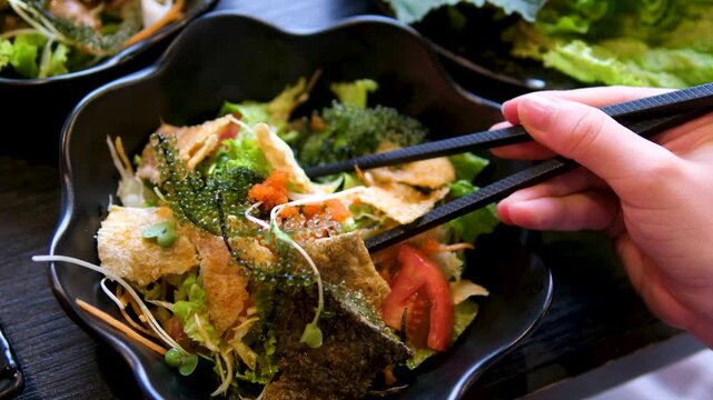 korean buffet seafood seaweed salad in black plates with dipping sauce close up 