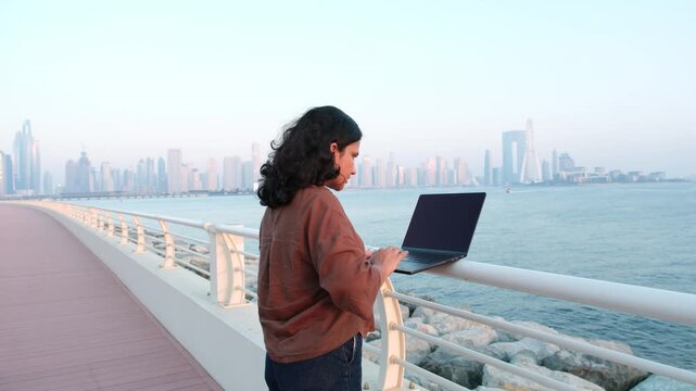 Online business coach working remotely by Dubai waterfront skyline during sunset video