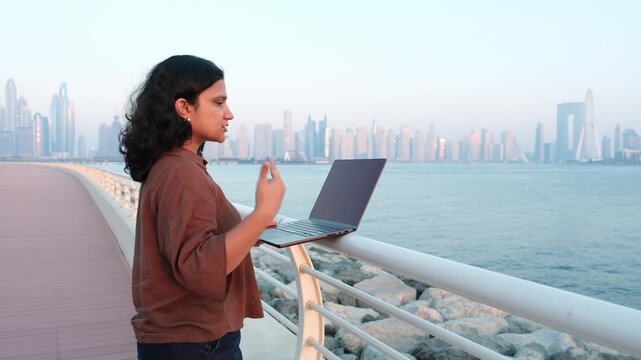 Content creator working remotely at Dubai waterfront with cinematic skyline sunset video