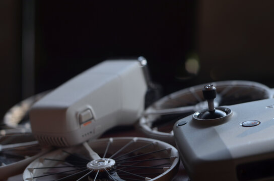 White consumer drone and remote control on a wooden table