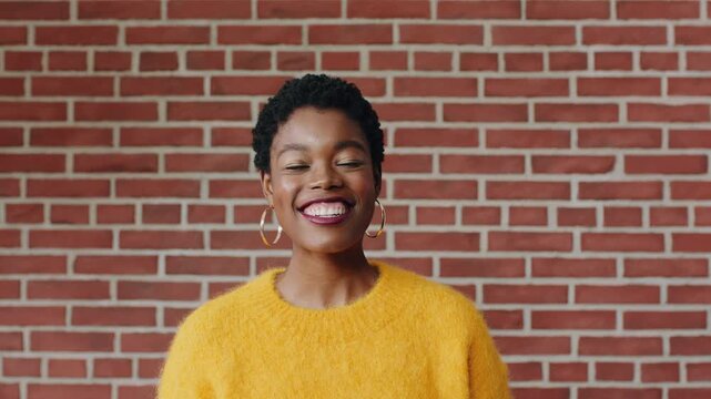 Face, confident and black woman with laugh by brick wall, funny memory and remember joke for smile. Portrait, space and female person with cheerful reaction for comic experience, humor and happiness