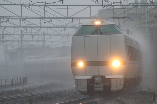 激しい雨の中、水しぶきを上げて力走する特急列車