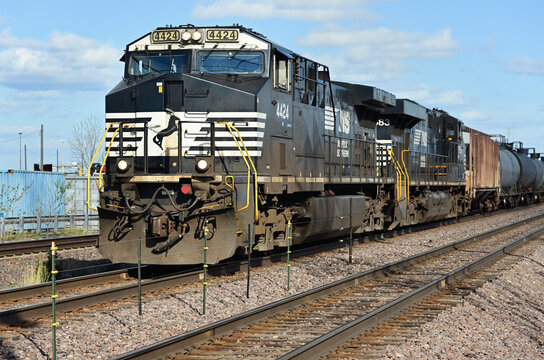A pair of Norfolk Southern Railway locomotives power a westbound ethanol train on Union Pacific tracks while passing through a near western Chicago suburb.