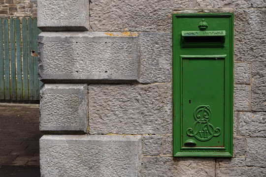 Vintage Green Irish Post Box on Stone Wall Background with Copy Space