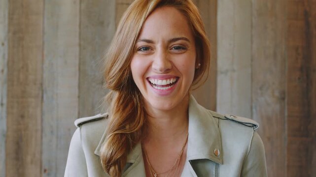 Face, business and happy woman with laugh by wooden wall, professional and confidence for hiring. Portrait, recruiter and hr manager with pride for talent acquisition, headhunter career and about us