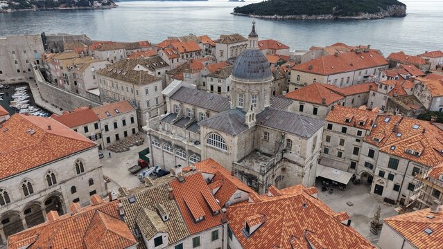 Aerial view of Dubrovnik Old Town and its medieval city walls. Cinematic shot of the UNESCO World Heritage site featuring limestone streets and terracotta roofs in Croatia.