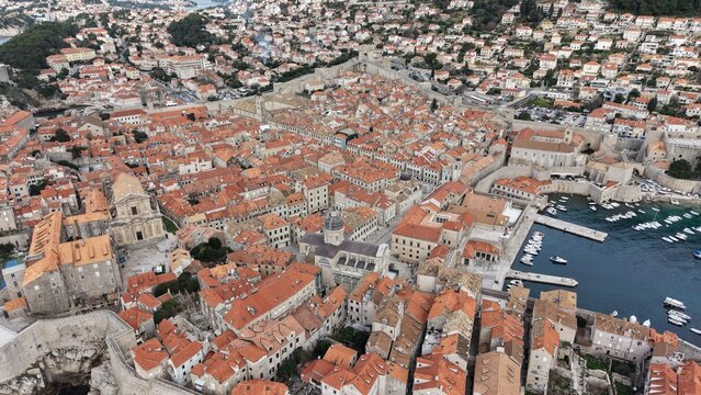 Aerial view of Dubrovnik Old Town and its medieval city walls. Cinematic shot of the UNESCO World Heritage site featuring limestone streets and terracotta roofs in Croatia.