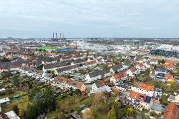 Fototapeta premium Aerial view of Stadtmitte district in Wolfsburg with residential area and industrial skyline