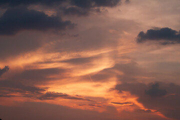 Obraz premium Vibrant sunset clouds glowing with rich orange and purple tones creating a dramatic atmospheric sky background with natural evening beauty.