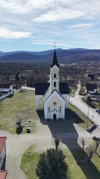 aerial view of St. Anthony of Padua Church in Dreznik Grad. Cinematic drone orbit of a historic Catholic church in the Croatian countryside near Plitvice Lakes
