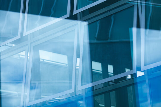 Open windows with beautiful reflections of the modern business centre made of glass. Urban futuristic style. Outdoor shot