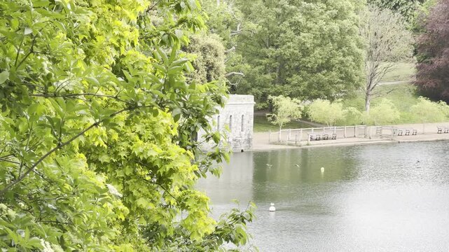 Stone boathouse on calm park lake timelapse