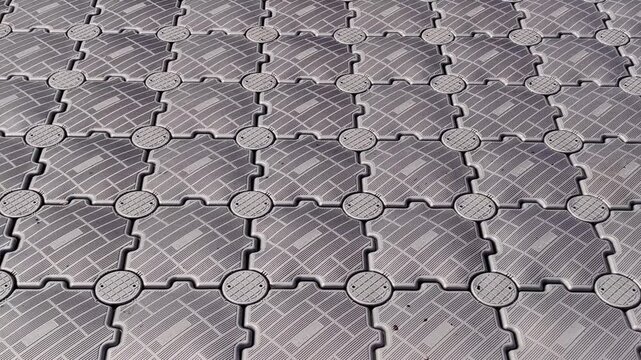 calm water surface with floating jetty made interlocking plastic modules, creating gentle, rhythmic wave-like motion perfect for soothing and abstract background.