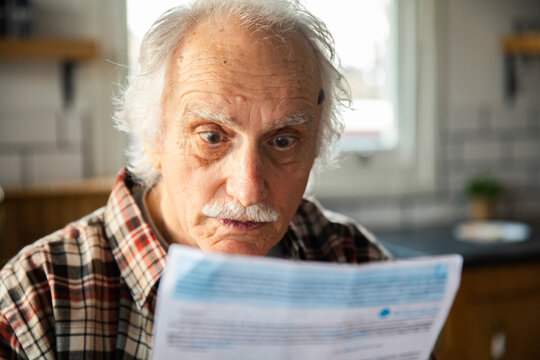 Senior man shocked reading bill at home