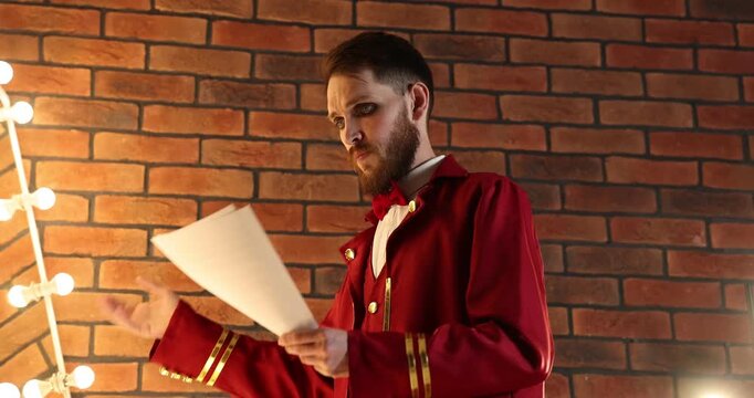 Actor with script rehearsing his lines near mirror in dressing room, low angle view