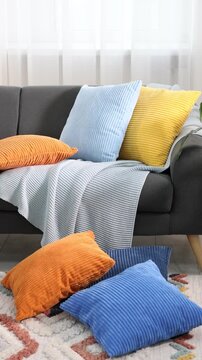 Soft cushions in colorful pillowcases on sofa indoors. Camera moving left